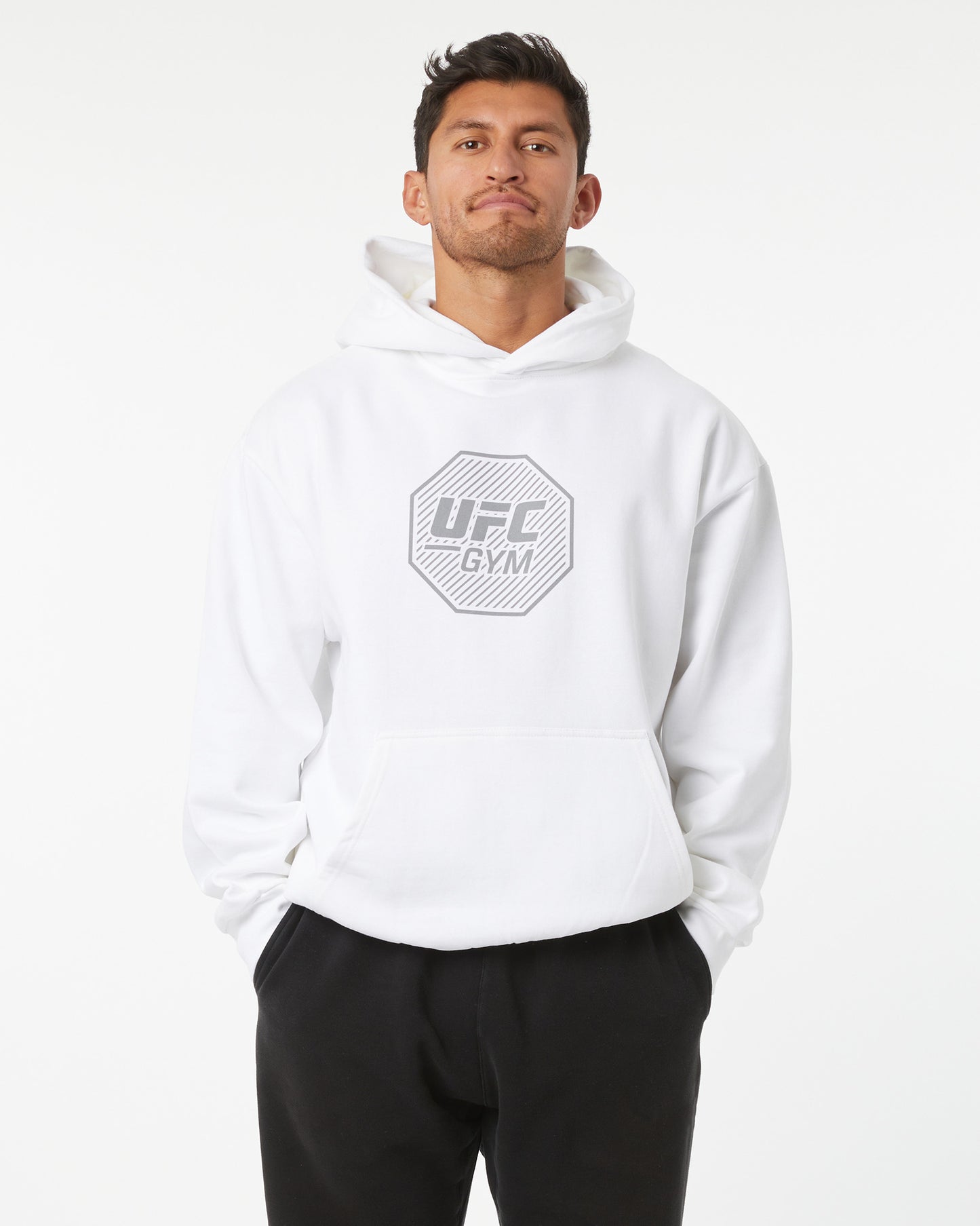 Man wearing a white UFC Gym hoodie on a white background facing forward
