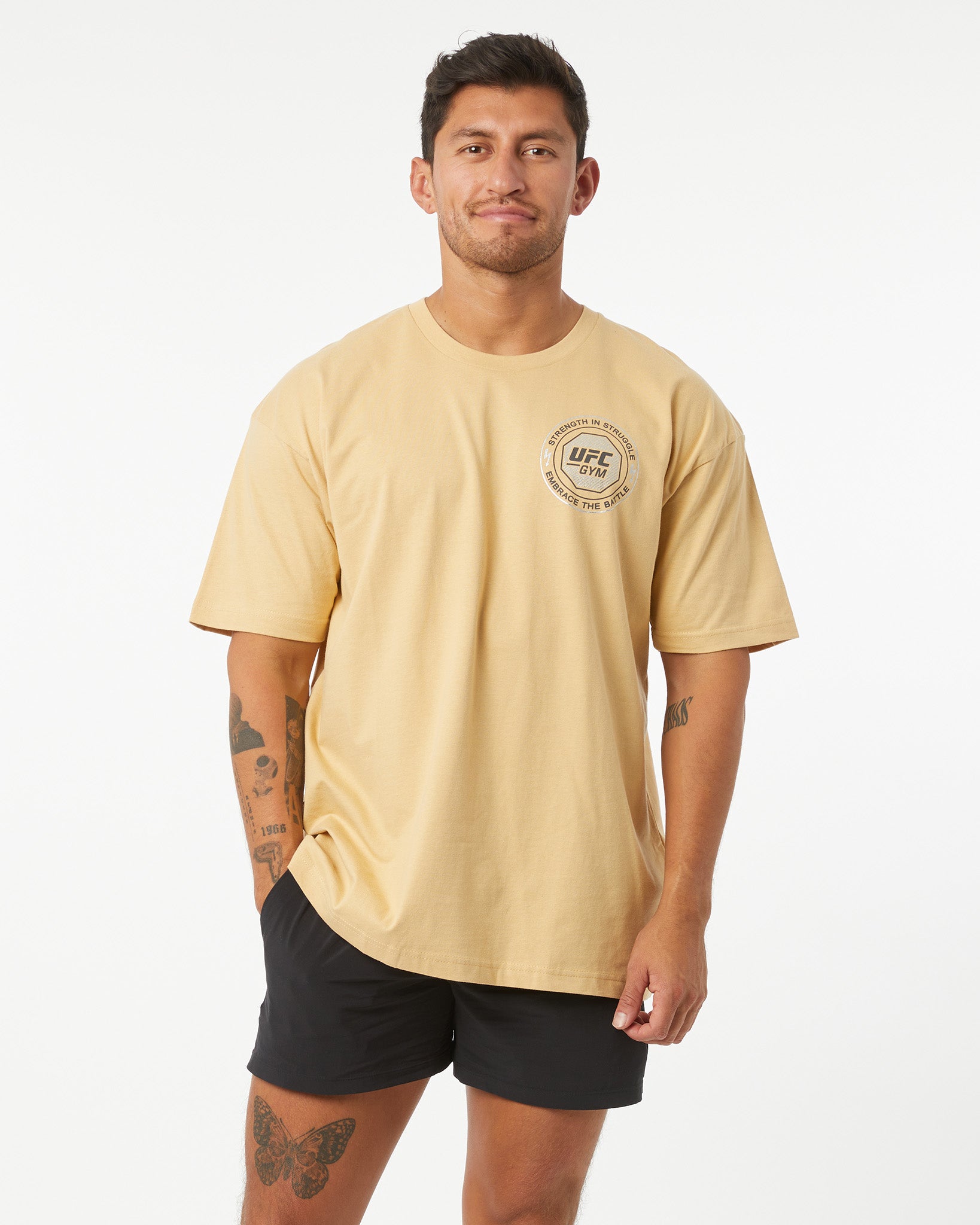 Man wearing a beige t-shirt with a UFC logo on a white background