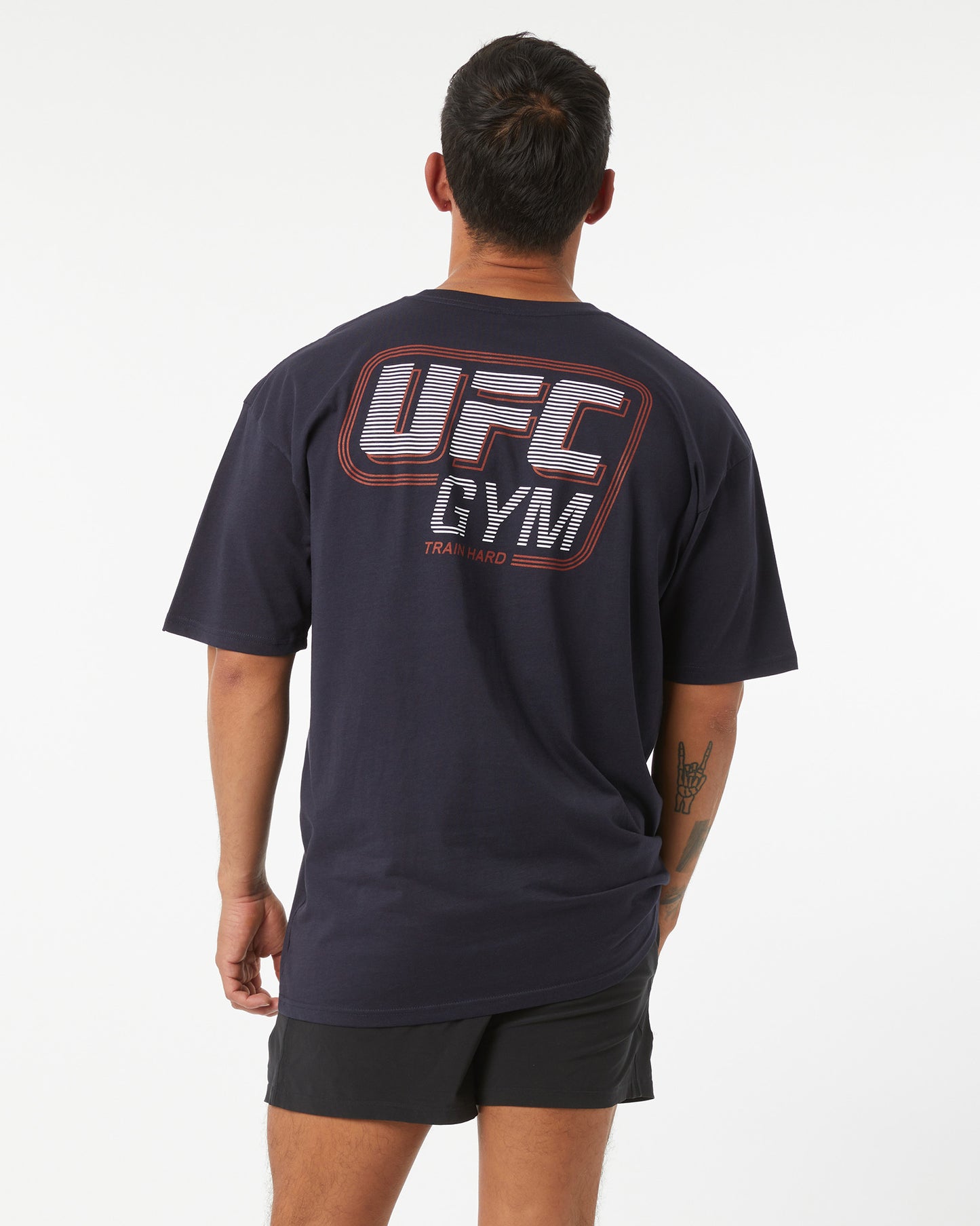 Person wearing a navy UFC Gym t-shirt on a white background