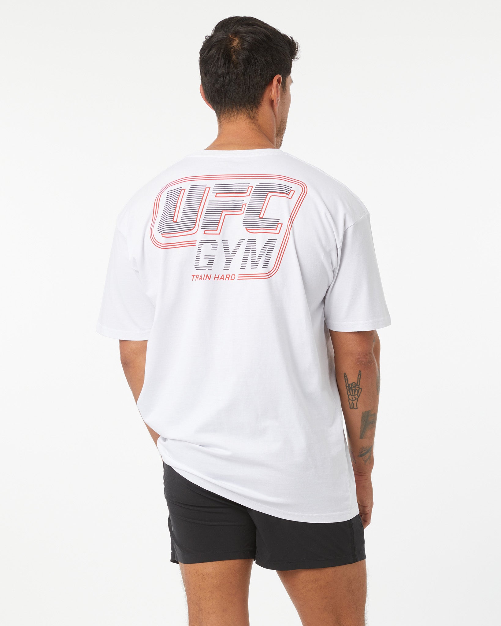 Person wearing a white UFC Gym t-shirt on a white background