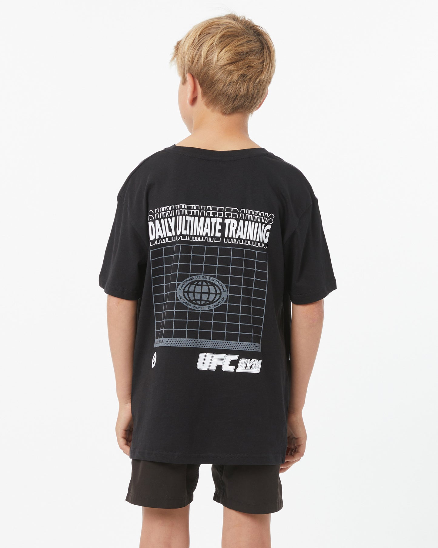 Child wearing a black UFC t-shirt with graphics on the back against a white background facing backward